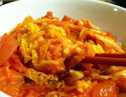 極食キング」（土山しげる）のトマトキムチ炒め卵黄のせドンブリ