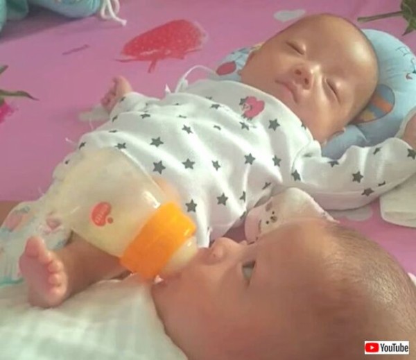 すやすやピーの隣でごくごくごく ちっちゃな赤ちゃん お兄ちゃんに足でミルクを飲ませてる マランダー