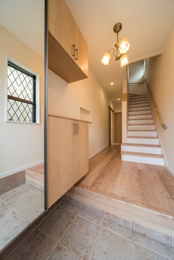 玄関ホールから上がる階段とアンティーク調のスズランのシャンデリア 注文住宅ブログ 大阪京都で注文建築専門の工務店は匠建枚方